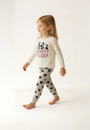 Haut à manches longues blanc avec le texte "BEAUTY SLEEP" et un graphique de panda, associé à un legging gris avec des motifs de cœurs noirs.