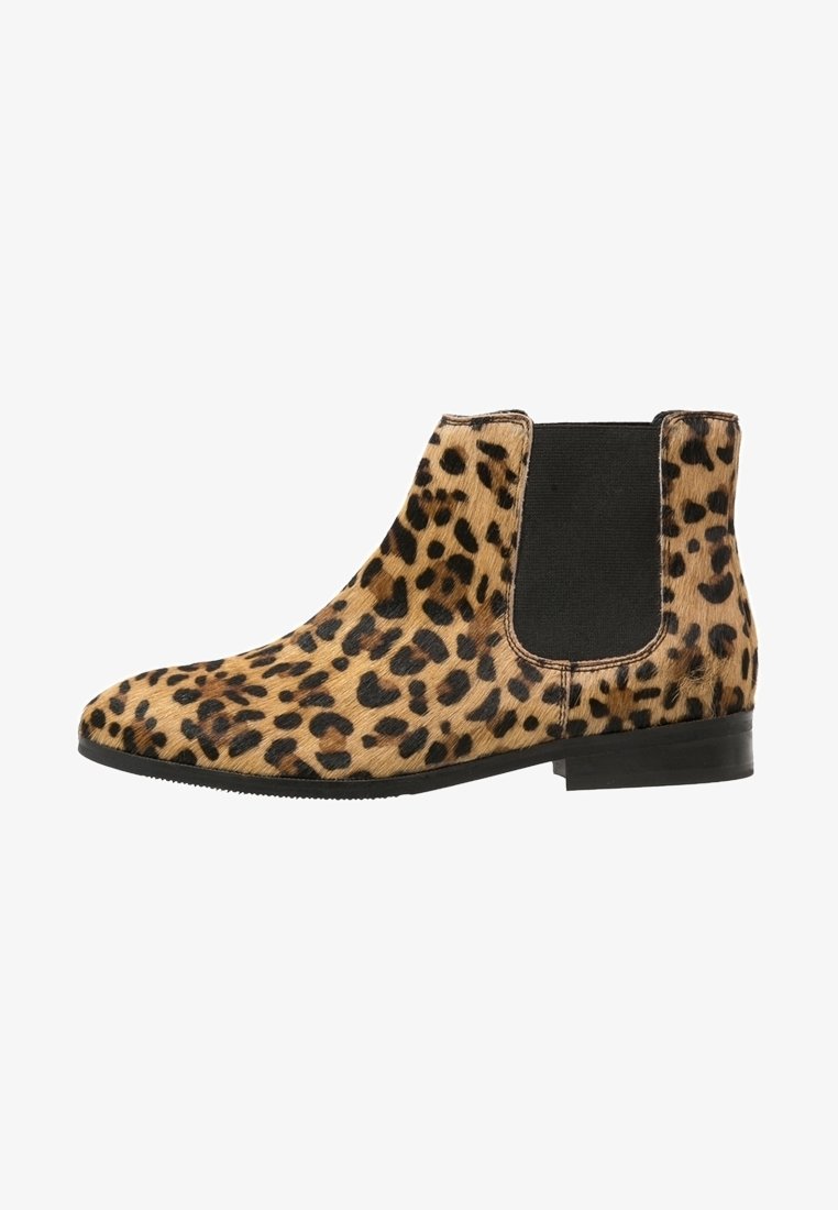 Bottine à talon bas avec fourrure à imprimé léopard, panneau latéral élastique noir, et bout pointu.