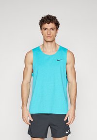 Turquoise athletic tank top with a round neckline and black Nike logo. The fabric appears smooth and lightweight. Worn with dark shorts.