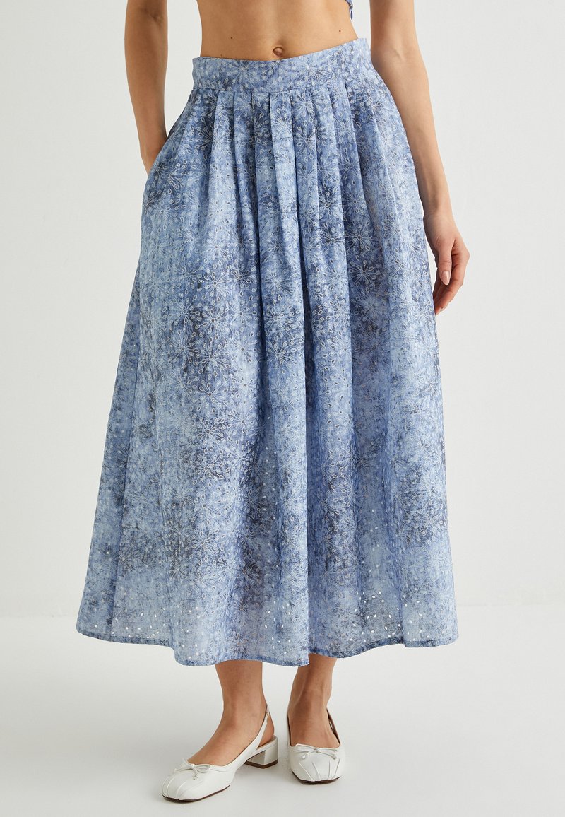 Maxi-Rock mit blauem Muster und Falten, aus leichtem Stoff gefertigt. Verfügt über eine hohe Taille und Seitentaschen. Mit subtiler Stickerei verziert.