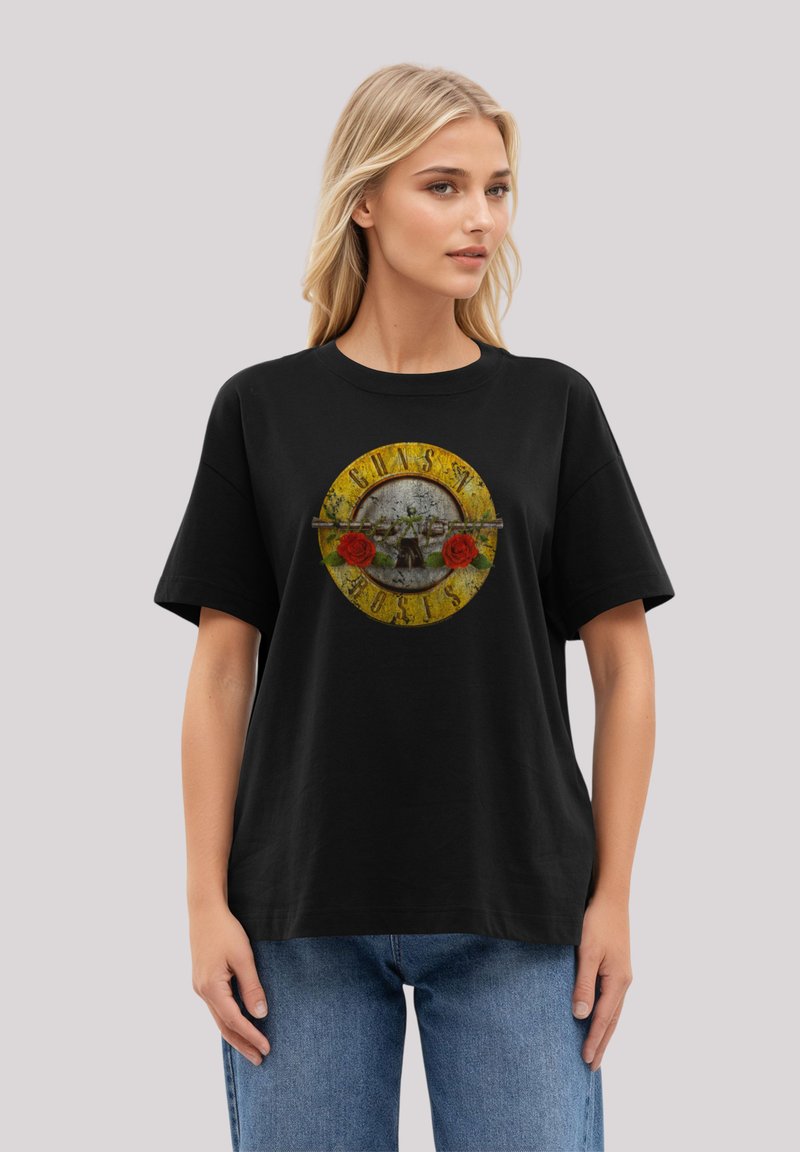 Black cotton t-shirt with a round graphic featuring a skull, roses, and text. Short sleeves, relaxed fit, and a crew neckline.