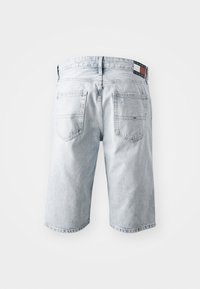 Lys blå denimshorts med rett snitt, fem lommer og et logopatch på linningen. Slitte detaljer gir tekstur.
