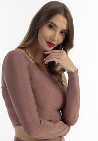Stofroze langemouw cropped top met een glinsterende textuur, met een ronde halslijn en gecombineerd met een chunky gouden ketting.
