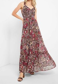 Maxiklänning i genomskinligt tyg med blommigt och insektstrykt. Vinrött bakgrund med lager av volanger vid fållen. Har justerbara axelband.