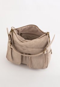 Beige læderhåndtaske med lynlåslukning, flere rum og guldhardwaredetaljer. Glat tekstur og syning detaljer overalt.