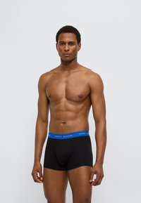 Μαύρα βαμβακερά boxer briefs με μπλε ελαστική μέση, με το λογότυπο "TOMMY HILFIGER". Ο σχεδιασμός είναι απλός και εφαρμοστός.