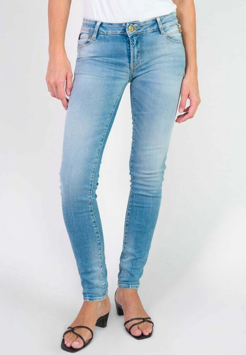 Jean skinny bleu clair en denim, avec un design classique à cinq poches et des boutons en laiton. Texture lisse, finition délavée moyenne.