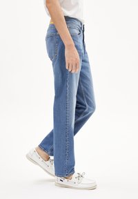 Lichtblauwe rechte jeans gemaakt van denim, met een rits- en knoopsluiting aan de voorkant, vijf zakken en een licht vervaagde afwerking.