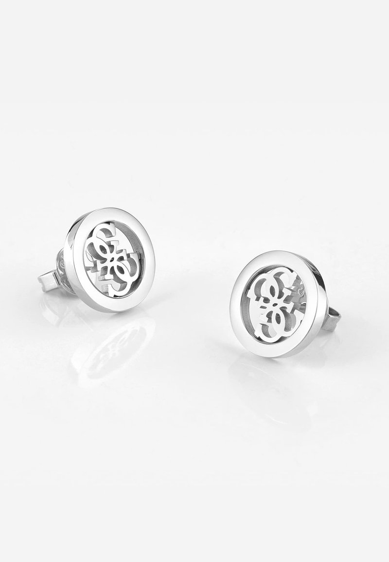 Boucles d'oreilles en argent avec un design circulaire comportant un motif découpé. Surface lisse et réfléchissante avec une finition polie.