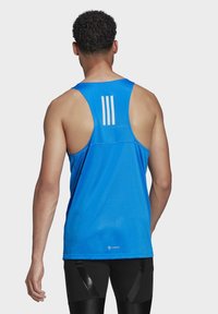 Débardeur de sport bleu pour homme avec un tissu texturé, un dos nageur et trois bandes blanches verticales sur le haut du dos.