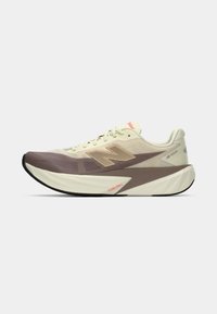 Beige and brown athletic shoe with mesh upper, thick sole, and prominent "N" logo. Features laces and "FuelCell" branding on the side.