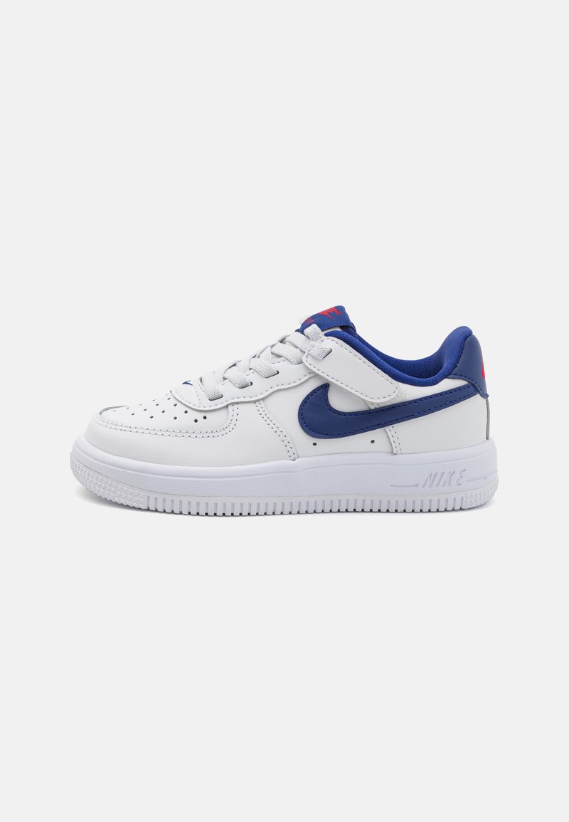 White leather sneakers with blue accents and a padded collar. Features perforations on the toe, laces, and a rubber sole. Nike logo visible.