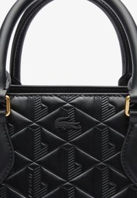 Borsa a tracolla in pelle nera con motivo geometrico in rilievo e logo in crocodile, due manici arrotondati e accessori metallici di colore oro.
