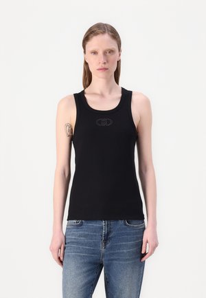 Musta ribbed-tyyppinen tanktoppi, jossa on pyöreä pääntie ja leveät hihnat, sisältäen hienovaraisen logoyksityiskohdan keskellä. Yhdistetty sinisiin farkkuihin.