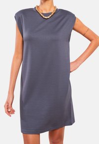 Szara sukienka bez rękawów o luźnym kroju, wykonana z gładkiego materiału. Posiada zaokrąglony dekolt oraz minimalistyczny design bez zdobień.