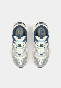 Zapatillas grises y blancas con un acabado texturizado, que presentan detalles en azul y un collar acolchado. Cordones pasados por ojales para un ajuste seguro.