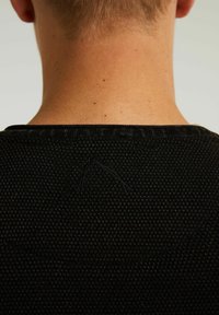 Czarny sweter z textured knit z prążkowanym kołnierzem i małym haftem w okolicy karku.