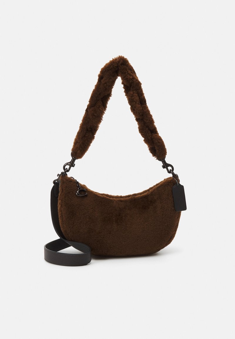 Sac d'épaule marron duveteux avec une longue bandoulière en cuir détachable et une courte poignée en peluche sur fond blanc.