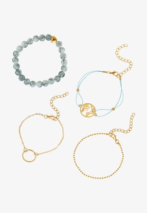 Vier Armbänder: eines mit grau-weißen Perlen und einem goldenen Herzen, eine goldene Kette mit einem Globus-Anhänger, ein gedrehter Ring und eine Kugelkette.