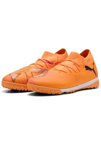 Lys orange fodboldstøvler med en struktureret overdel, elastisk sokkrave og en hvid sål med gummistifter. Puma-logo i sort.