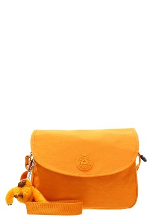 Sac bandoulière orange vif avec rabat à l’avant, logo circulaire embossé, sangle ajustable et petit porte-clés singe en peluche attaché.