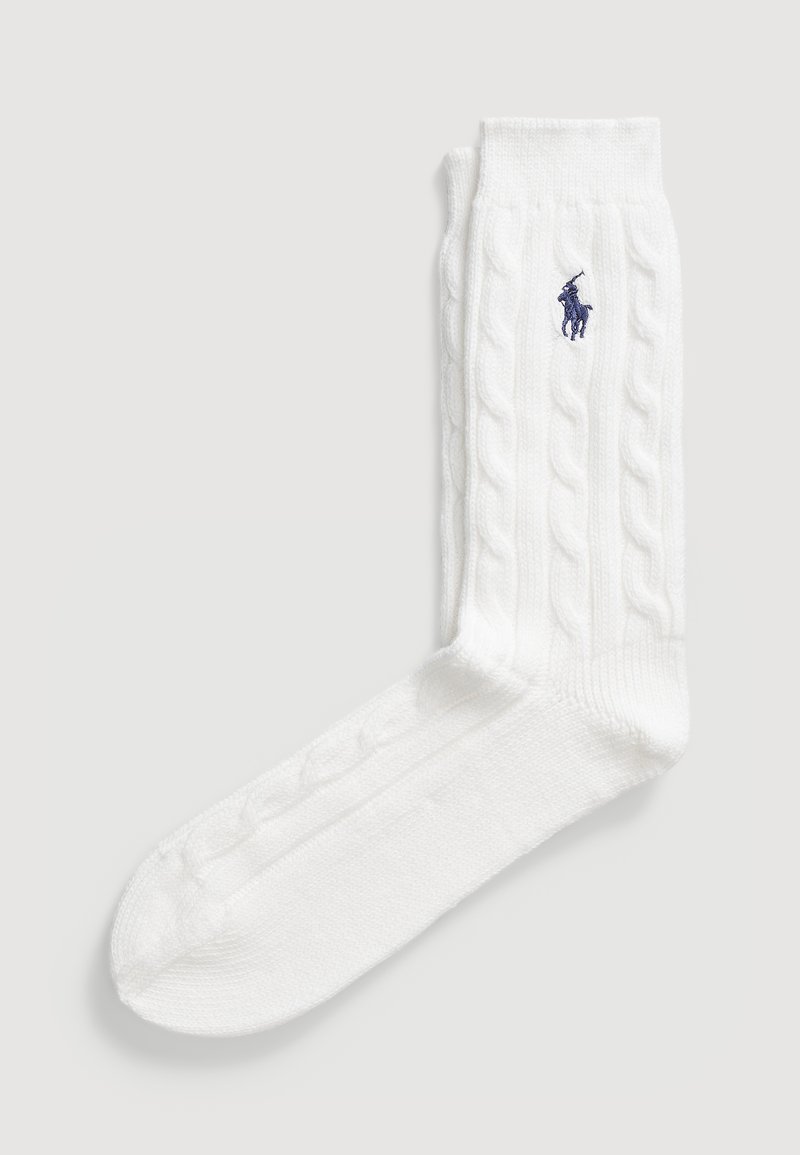 Vita kabelstickade strumpor med ribbad textur och en synlig marinblå logotyp. Mjuk material med en standard strumpform och förstärkt tå.