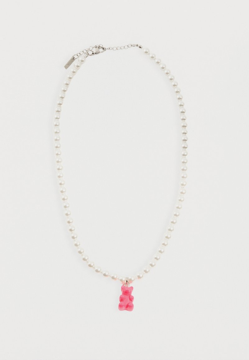 Λευκό κολιέ με χάντρες, ασημένιο κούμπωμα και με μικρό ροζ μενταγιόν σε σχήμα αρκουδάκι ζελέ στο κέντρο.