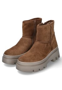 Botas de tobillo de ante marrón con una gruesa suela plataforma beige y un zipper lateral. El diseño incluye un forro interior suave y costuras mínimas.