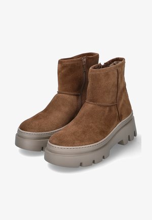 Bruine suède enkellaarsjes met een dikke, beige plateauzool en een zijrits. Het ontwerp heeft een zachte binnenvoering en minimale stiksels.