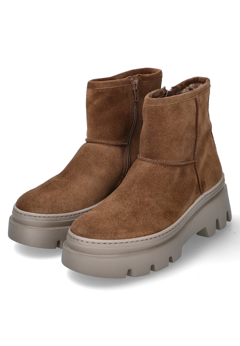 Botas de tobillo de ante marrón con una gruesa suela plataforma beige y un zipper lateral. El diseño incluye un forro interior suave y costuras mínimas.