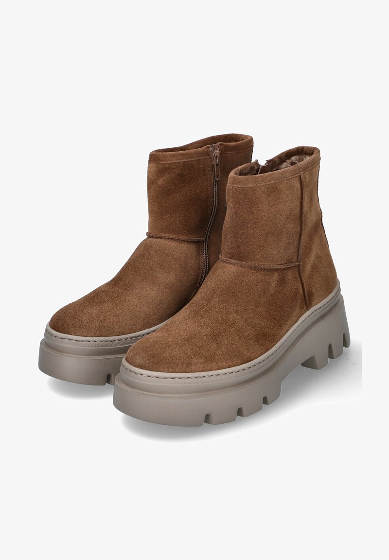 Botas de tobillo de ante marrón con una gruesa suela plataforma beige y un zipper lateral. El diseño incluye un forro interior suave y costuras mínimas.