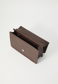 Borsa in pelle marrone di forma rettangolare, con chiusura a bottone argentato e apertura superiore. L'interno include una tasca con zip.