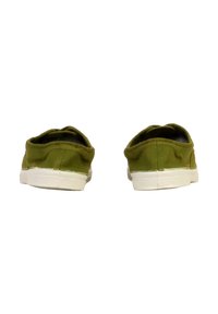Scarpe slip-on verdi in tela con una texture liscia, suola in gomma bianca e un design semplice. Cuciture a vista sul tallone.