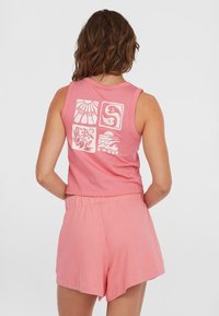 Roze katoenen mouwloze top met grafische ontwerpen op de rug, gecombineerd met bijpassende roze shorts met een elastische tailleband.