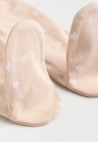 Helle rosa Socken mit einer weichen Textur, die kleine weiße Sternmuster und eine runde Zehenform aufweisen.