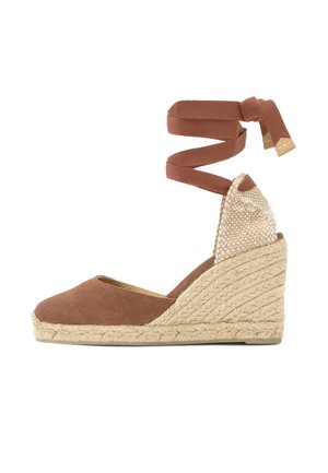 Hnedá plátená espadrilová obuv na klinovom podpätku s pletenou jutovou podrážkou a zaväzovaním okolo členku s kovovými koncami.