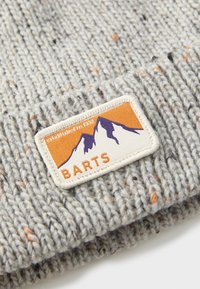 Közelről fényképezett szürke kötött sapka narancssárga és lila hegyi folttal, amelyen a "BARTS" felirat és az "1992-ben alapítva" szöveg szerepel.
