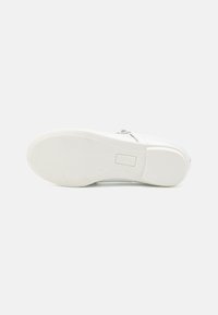 Weiße Schuhbasis mit strukturiertem Gummisohle, ausgestattet mit einem glatten Lederoberteil und minimalistischem Design. Kleines Markenlogo auf der Sohle.