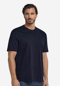 Mörkblå, kortärmad T-shirt i mjukt tyg, med rundad halsringning och avslappnad passform, utan synliga logotyper eller mönster.