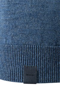 Strickmütze in Blau mit geripptem Bund. Sie hat ein strukturiertes Gewebe und ein kleines schwarzes Etikett mit dem Markennamen am unteren Rand.