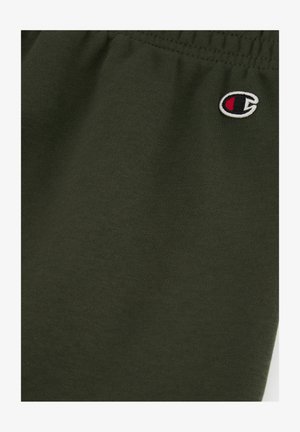 Tessuto di cotone verde scuro con vita elastica. Un piccolo logo ricamato in rosso, bianco e nero appare sul lato destro.
