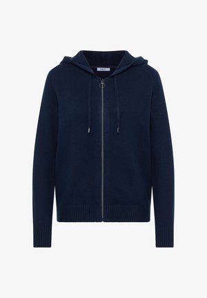 Tummansininen huppari, jossa on vetoketju edessä, resorit helmassa ja hihansuissa sekä kaksi kiristysnauhaa. Valmistettu pehmeästä neuloksesta ja minimalisella designilla.