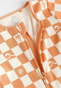 Combinaison zippée en coton pour bébé avec un motif à carreaux orange et crème, ornée de palmiers, de vagues et de motifs de soleil ; texture lisse, fermeture éclair centrale.