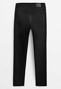 Jean noir slim fit avec deux poches arrière et une ceinture comportant des passants pour ceinture et un petit patch noir.