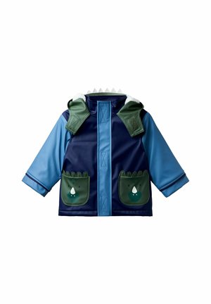 Chaqueta impermeable en azul y marino, con bolsillos verdes con diseños de animales, capucha texturizada y acentos dentados a lo largo del cuello.