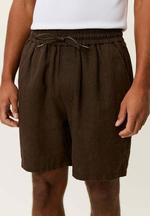 Braune, knielange Shorts mit Kordelzug, getragen von einer Person mit mittlerem Hautton, kombiniert mit einem weißen Oberteil.