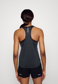 Black sleeveless athletic tank top with a racerback design. Features textured fabric and white accents at the sides and logo on the back.