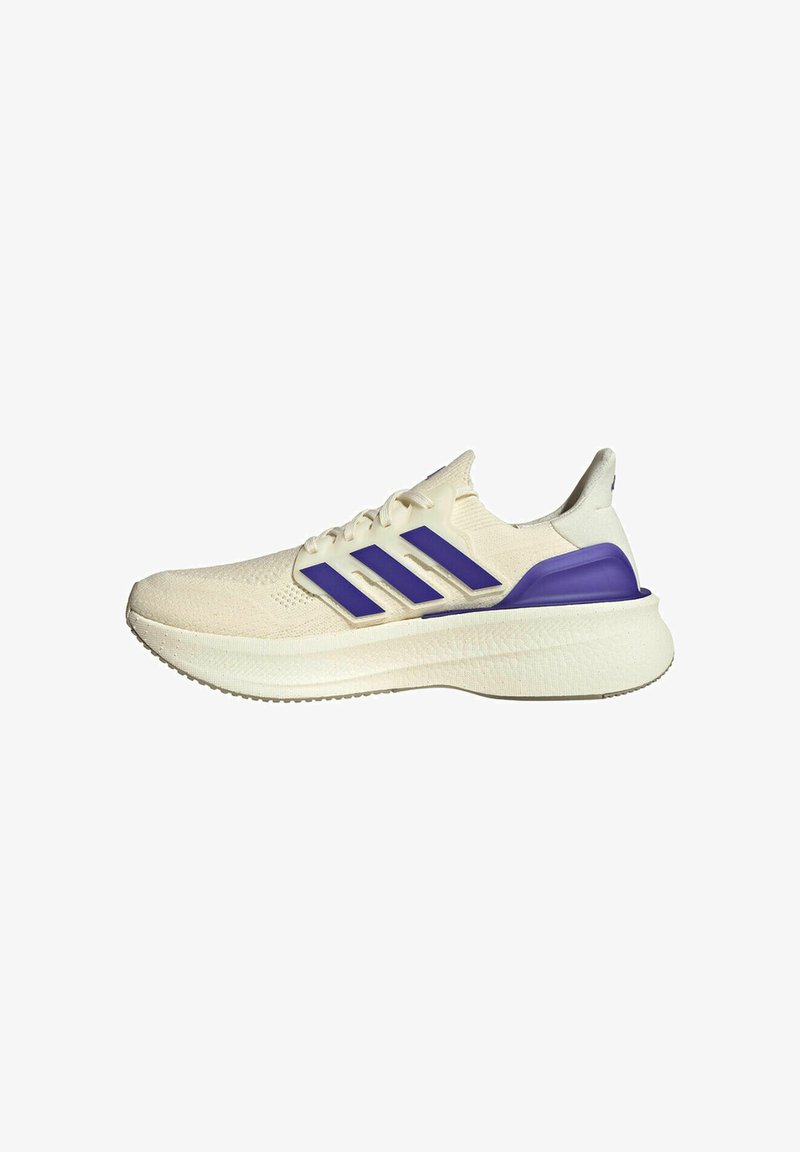 Chaussure de course couleur crème avec des rayures violettes et un soutien du talon, semelle texturée et fermeture à lacets, vue latérale sur fond blanc.