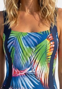 Énstykket badedragt med et tropisk palmebladsmønster i nuancer af grøn, blå og orange, med firkantet udskæring og marineblå sideaccenter.