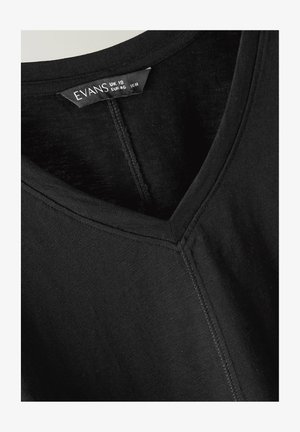 Zwart V-hals top met zichtbare middennaad en label met maat UK 18, EUR 46, US 14, merk Evans.